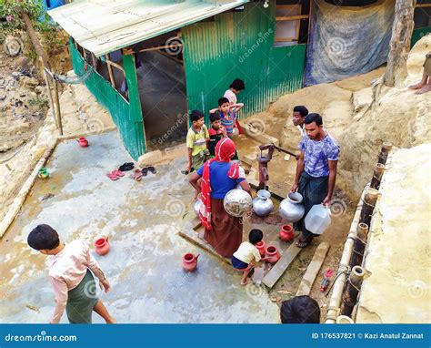 Refugee family recreating village well with bathtub bucket