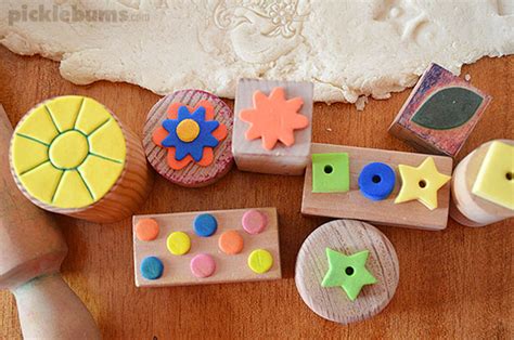 Twin toddlers stamping dough with floury palm prints